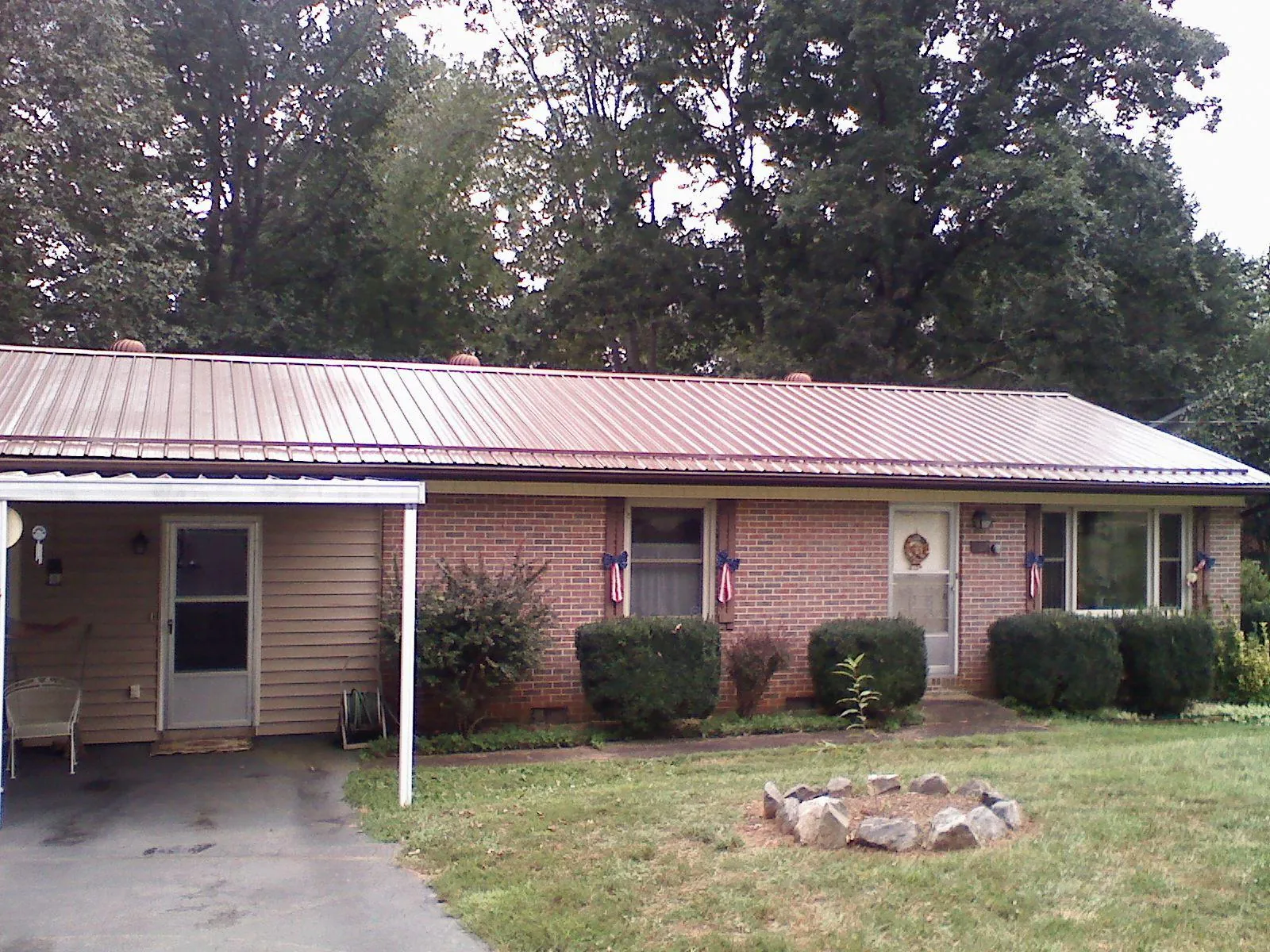 Bronze metal roof and carport on a brick ranch home — Roof Repair work by our crew in Pink Hill
