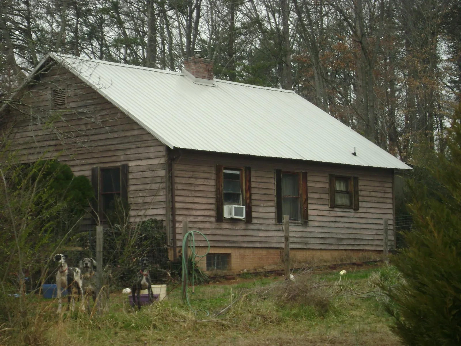 White metal roof on an old wood sided farmhouse, from a Metal Roof Installation job in Pink Hill